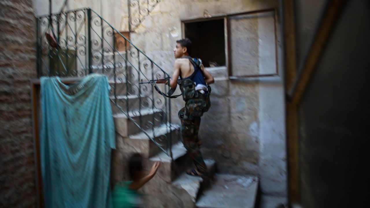 A fighter from the Islamic Front takes position in a building during clashes with Syrian regime forces Aleppo on July 21.