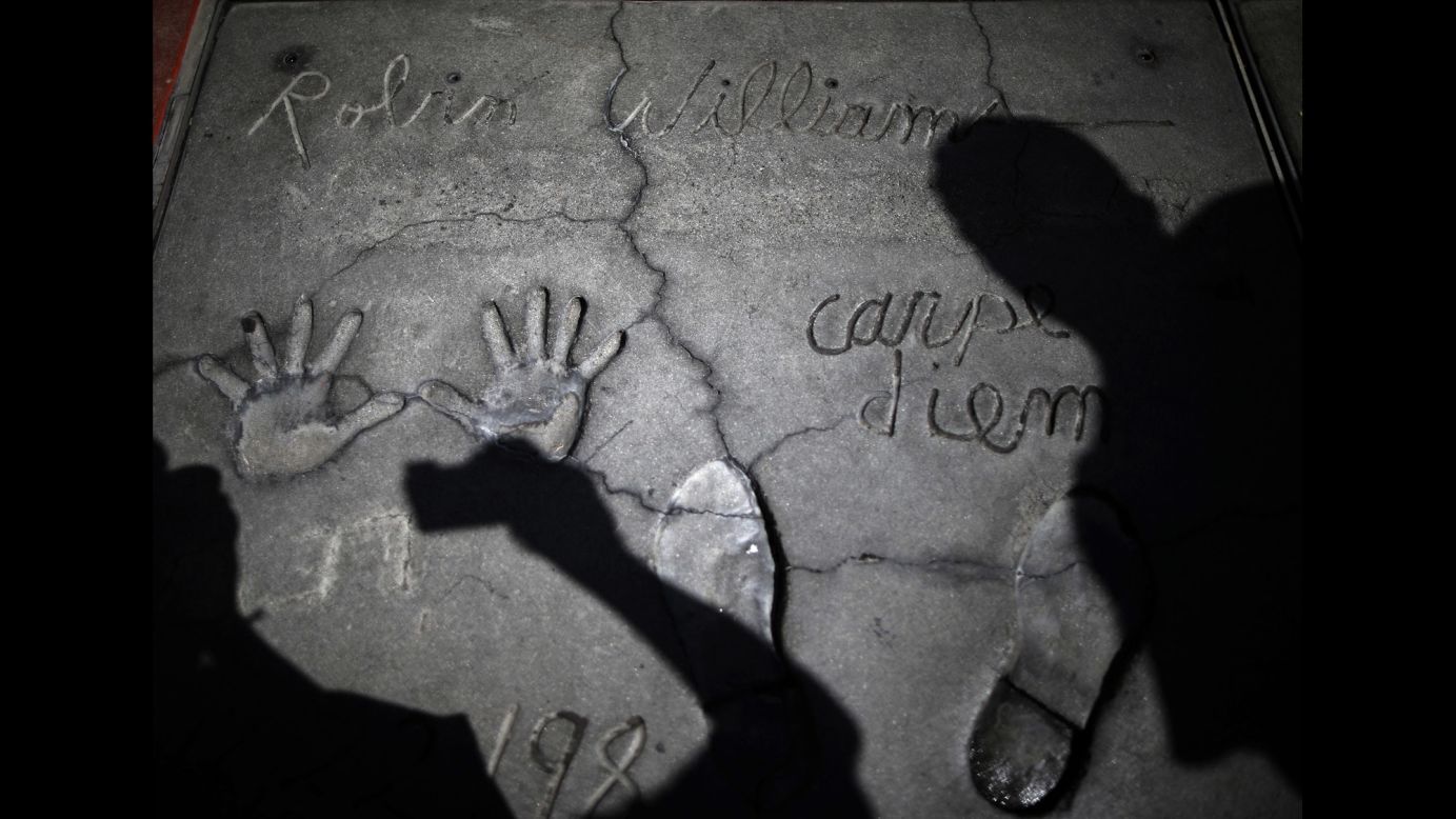 People in Los Angeles photograph Robin Williams' handprints and footprints at TCL Chinese Theater on Tuesday, August 12. The 63-year-old <a href="http://www.cnn.com/2014/08/11/showbiz/gallery/robin-williams/index.html">actor and comedian</a> was found dead at his Northern California home a day earlier. <a href="http://www.cnn.com/2014/08/14/showbiz/robin-williams-parkinsons-disease/index.html">Investigators suspect</a> it was suicide. 