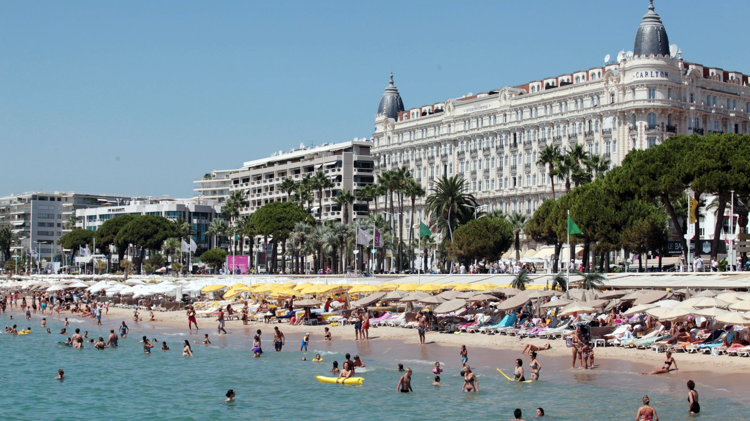 People frolic in the water at a beach in Cannes in August 2012.