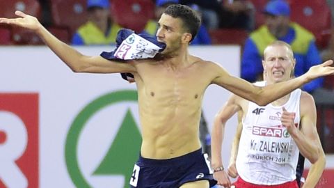 French athlete Mahiedine Mekhissi-Benabbad strips off his running vest in the home straight of the 3,000m steeplechase.
