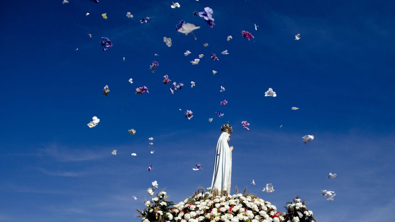 Flowers are thrown in the air Wednesday, August 13, as the Our Lady of Fatima statue is carried during a pilgrimage to Fatima Sanctuary in Fatima, Portugal. It is one of the world's most important Catholic shrines dedicated to the Virgin Mary, according to <a href="http://www.portugal.com/fatima/" target="_blank" target="_blank">Portugal.com.</a>