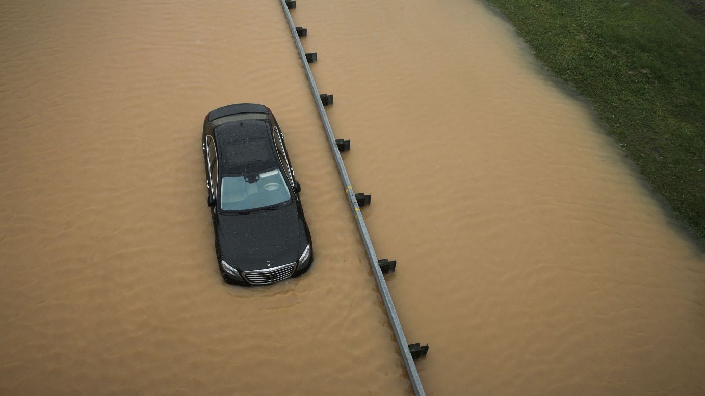 A partially submerged car sits on a flooded section of Interstate 695 in Baltimore on Tuesday, August 12, after heavy rains fell across the Mid-Atlantic region of the United States.