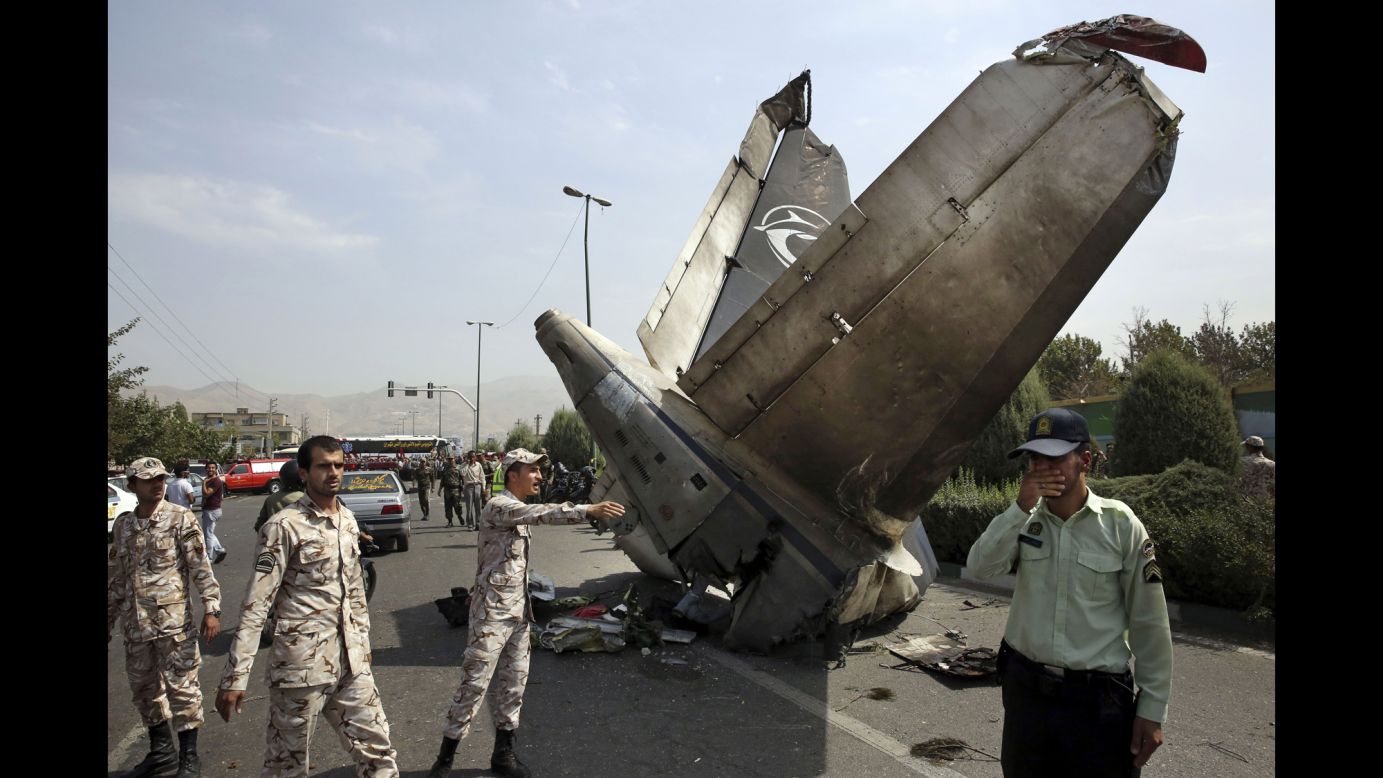 Iranian Revolutionary Guards and police officers inspect the site of a <a href="http://www.cnn.com/2014/08/10/world/meast/iran-plane-crash/index.html">passenger plane crash</a> in Tehran, Iran, on Sunday, August 10. Sepahan Airlines Flight 5915 was carrying 40 passengers and a crew of eight when it went down shortly after takeoff, according to official news agencies in Iran.