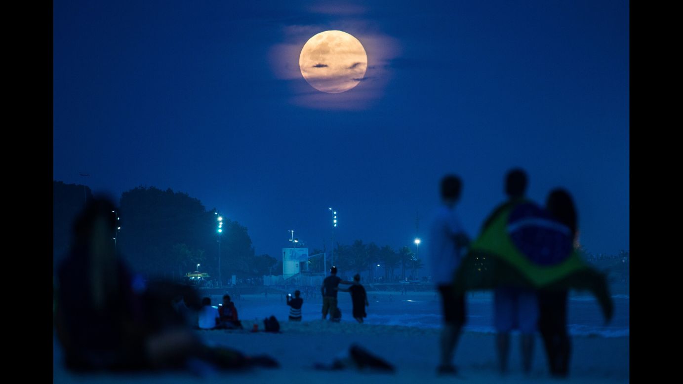 People watch a full moon known as a "supermoon" Sunday, August 10, at Ipanema Beach in Rio de Janeiro. <a href="http://www.cnn.com/2014/08/10/world/gallery/supermoon-0810/index.html">Supermoons</a> happen when the moon becomes full on the same day as its perigee -- the point in the moon's orbit when it's closest to Earth. Full moons occur near perigee approximately every 13 months, according to NASA.