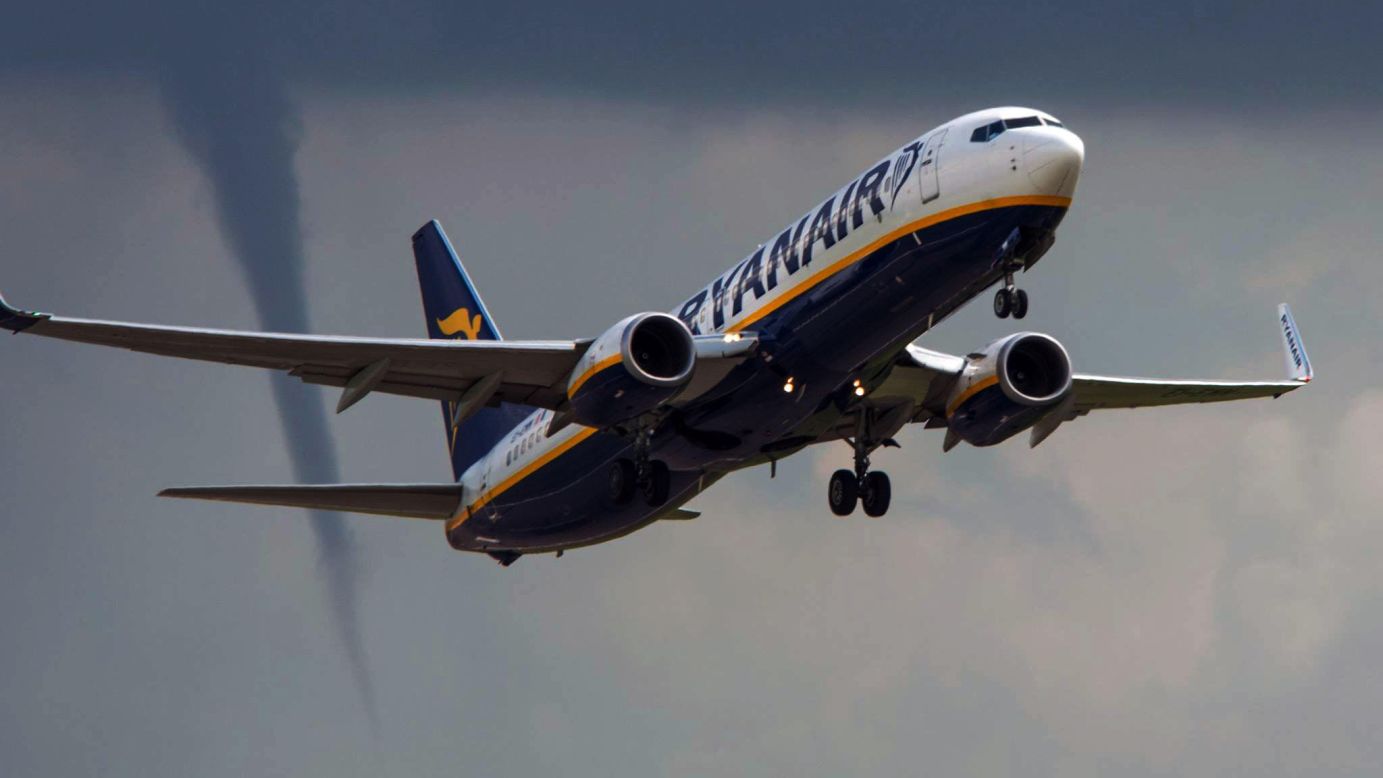 A Ryanair commercial jet takes off from East Midlands Airport in Derby, England, as a tornado funnel forms nearby on Thursday, August 14.