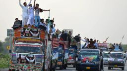 Supporters of opposition leader Imran Khan travel past Swabi on August 14, as they journey towards Islamabad for an anti-government rally..