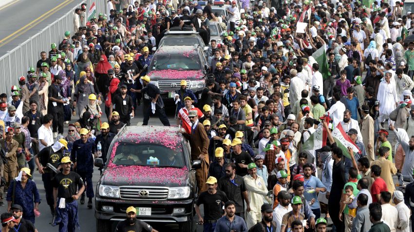 Followers of Tahir ul Qadri escort a vehicle carrying the cleric through Pakistan's eastern city of Lahore on August 14.