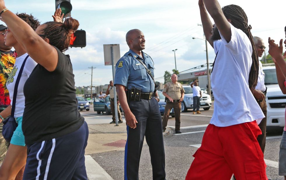 State Highway Patrol Capt. Ron Johnson smiles at demonstrators on August 14, 2014. Johnson was appointed to lead security as state troopers took over after days of clashes between protesters and local police.