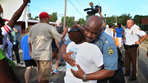 Missouri State Highway Patrol Capt. Ron Johnson gets a hug from Angela Whitman as protesters march on  Aug. 14.