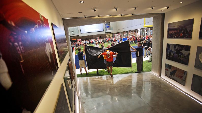 Fans run through a banner to be the first to tour the Hall of Fame. The 94,000-square-foot facility features a 150-seat theater and a 45-yard football field.