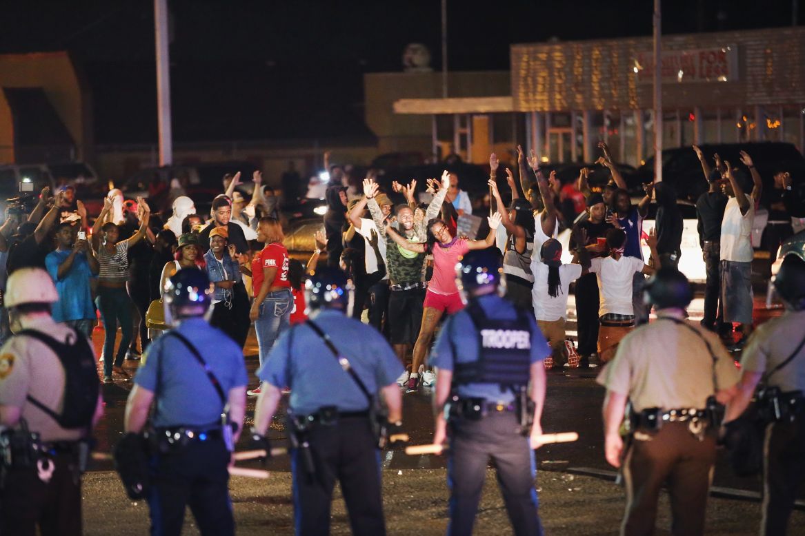 Missouri State Highway Patrol officers listen to taunts from demonstrators during a protest on Friday, August 15, 2014.