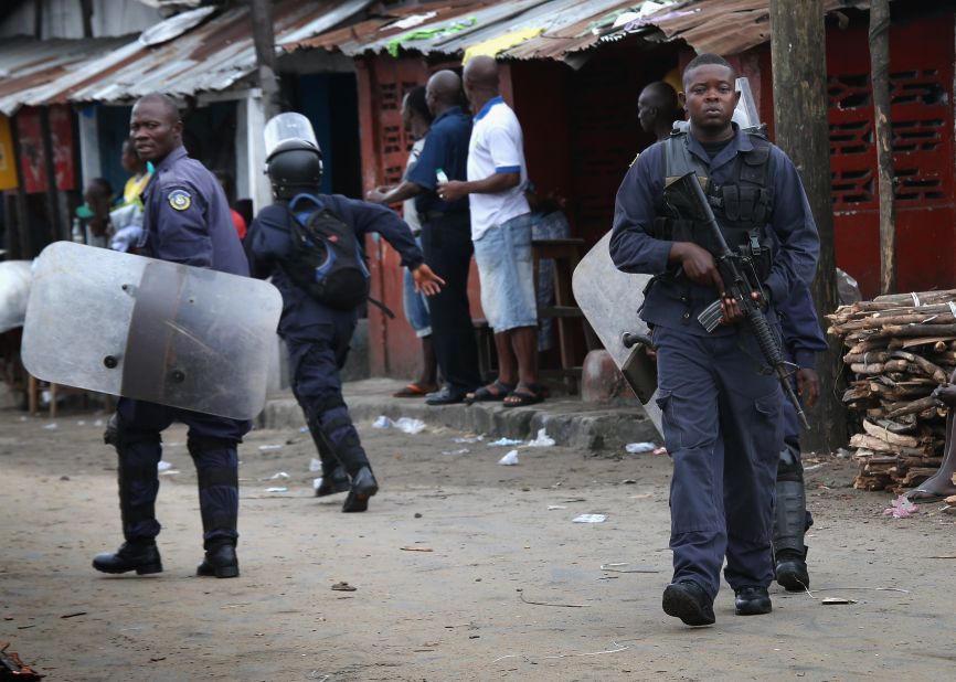 Liberian police depart after firing shots in the air while trying to protect an Ebola burial team in the West Point slum of Monrovia on August 16, 2014. A crowd of several hundred local residents reportedly drove away the burial team and their police escort. The mob then forced open an Ebola isolation ward and took patients out, saying the Ebola epidemic is a hoax.