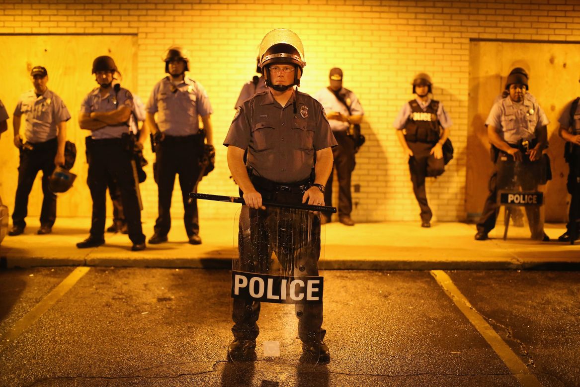 Police stand guard before the midnight curfew on Saturday, August 16, 2014.