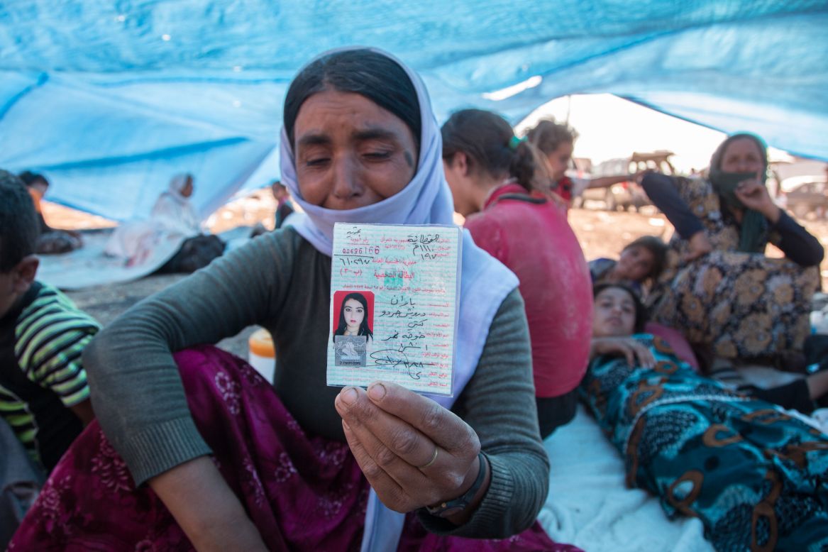 A mother shows the identity card that belonged to her 20-year-old daughter Baran, who was killed by shrapnel while pulling a child to safety.