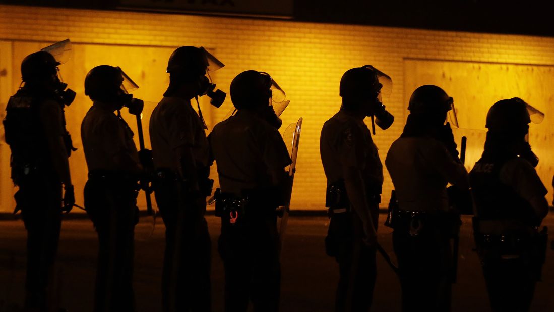 Police wait to advance after using tear gas to disperse protesters August 17, 2014.