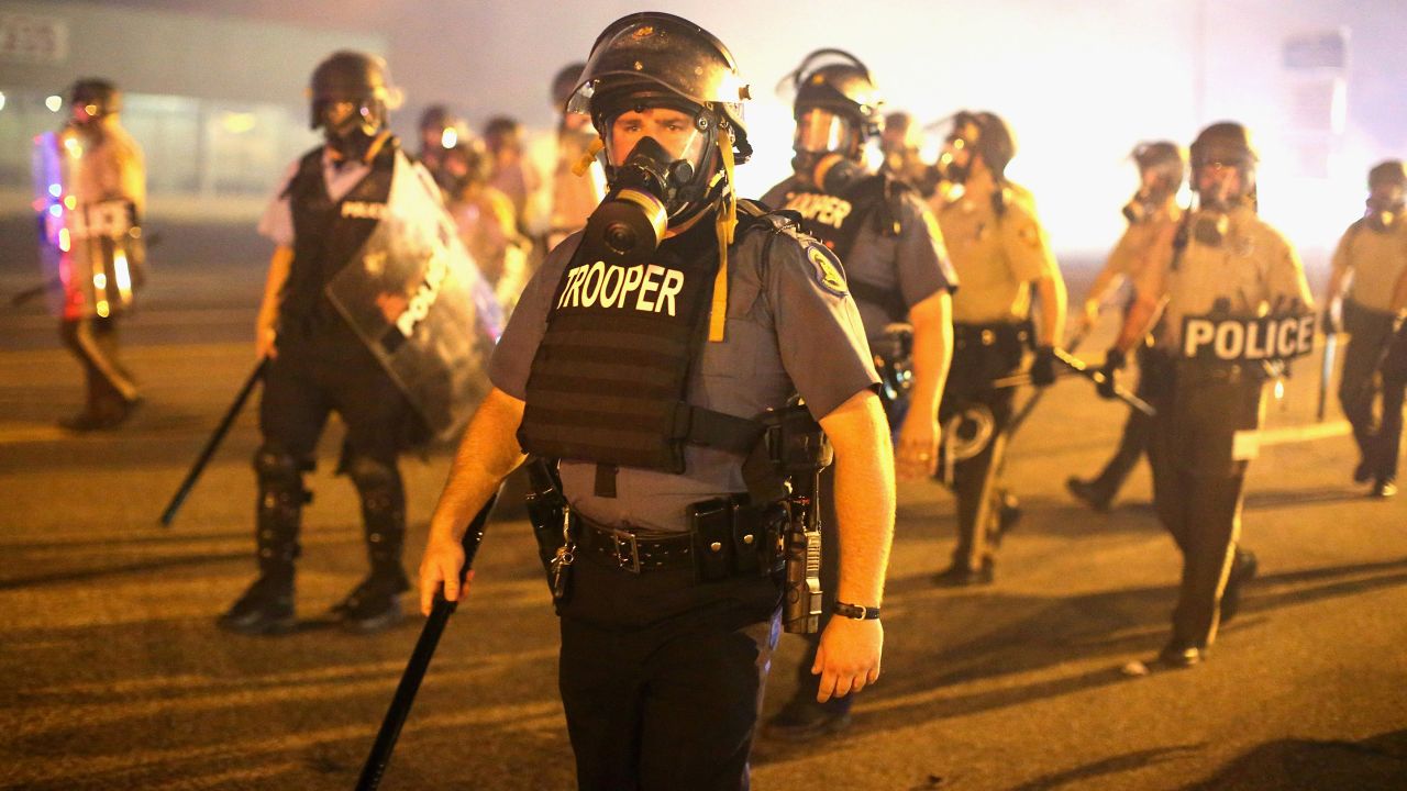Police advance through a cloud of tear gas on August 17, 2014. Most of the crowd had dispersed after a curfew went into effect at midnight, St. Louis County authorities said.
