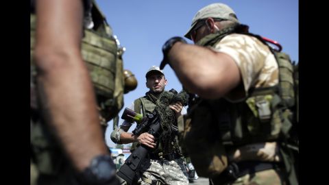 Ukrainian soldiers carry weapons at a checkpoint near Debaltseve on Saturday, August 16.
