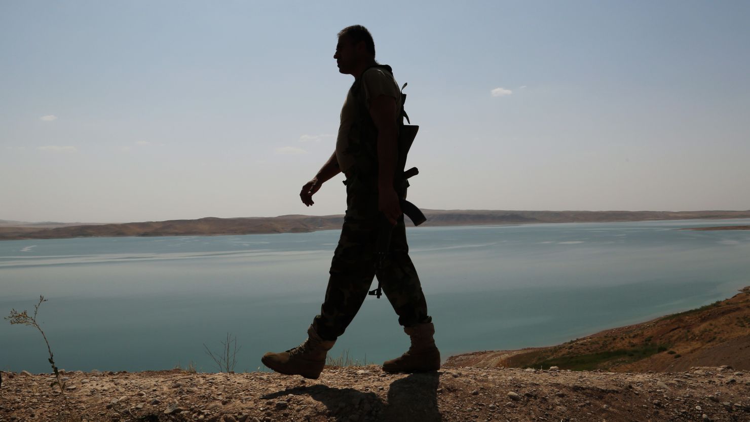 A Kurdish peshmerga fighter patrols near the Mosul Dam outside Mosul, Iraq in August.