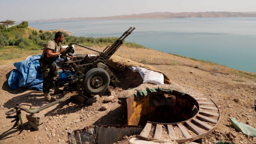 A Kurdish peshmerga fighter prepares his weapon at his combat position near the Mosul Dam at the town of Chamibarakat outside Mosul, Iraq on August 17, 2014.