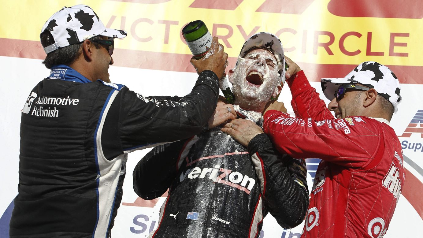 IndyCar drivers Tony Kanaan, right, and Juan Pablo Montoya, left, celebrate with Will Power after Power won at the Milwaukee Mile racetrack Sunday, August 17, in West Allis, Wisconsin. Kanaan and Montoya hit Power with <a href="http://www.wistatefair.com/wp/original-cream-puffs/" target="_blank" target="_blank">cream puffs</a> — a popular staple of the Wisconsin State Fair.