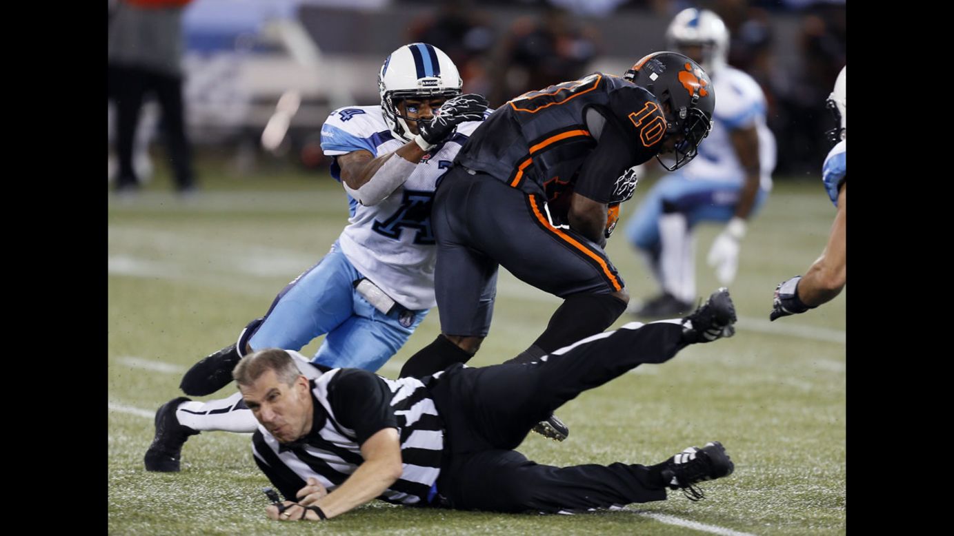 Adam Paradowski, a referee of the Canadian Football League, gets knocked over Sunday, August 17, during a game in Toronto between the Toronto Argonauts and the BC Lions.