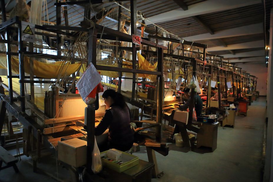 These four-meter-high machines are operated by two craftsmen at the same time -- one sits on top the machine sorting threads, the other sits at the opposite end and weaves. Each team can produce only five centimeters of yunjin per day.