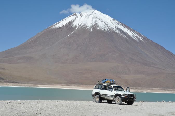 The aquamarine surface of Laguna Verde in Bolivia brilliantly captures the conical Licancabur volcano in the reflected surface.