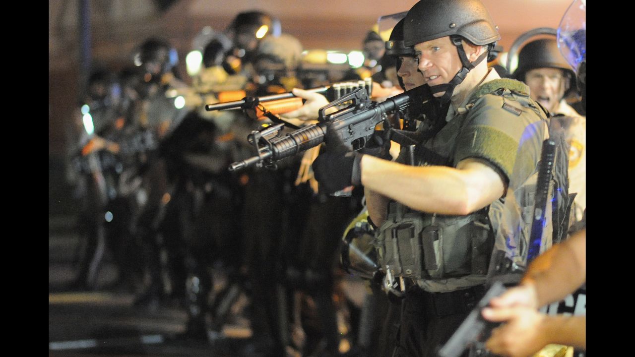 Officers stand with weapons drawn during a protest on West Florissant Avenue on August 18, 2014.
