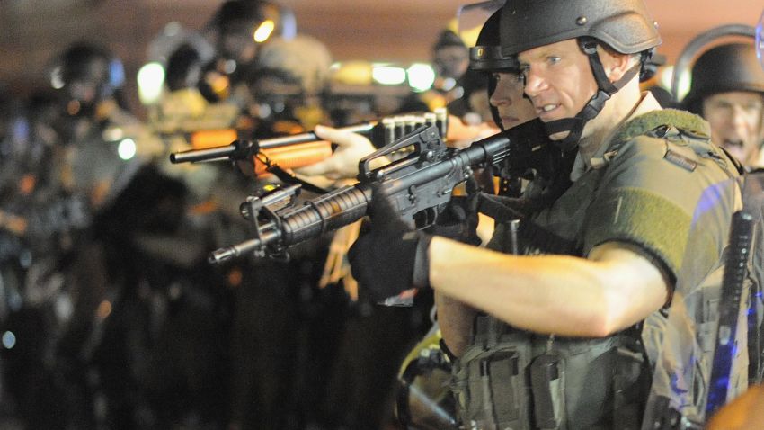 Police stand in a line with weapons drawn during a protest on West Florissant Avenue in Ferguson, Missouri, on August 18.
