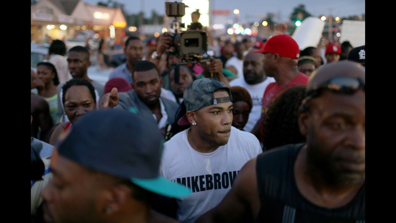 Musician Nelly, center, joins demonstrators in Ferguson on August 18, 2014.