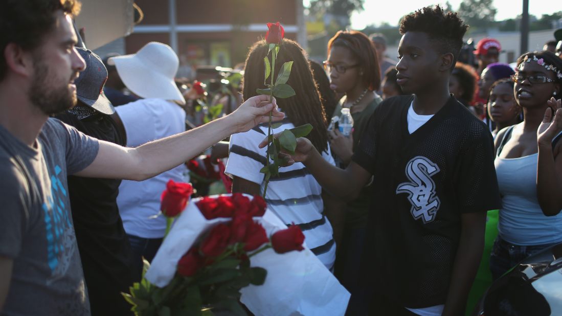 Demonstrators receive red roses as they protest August 18, 2014.