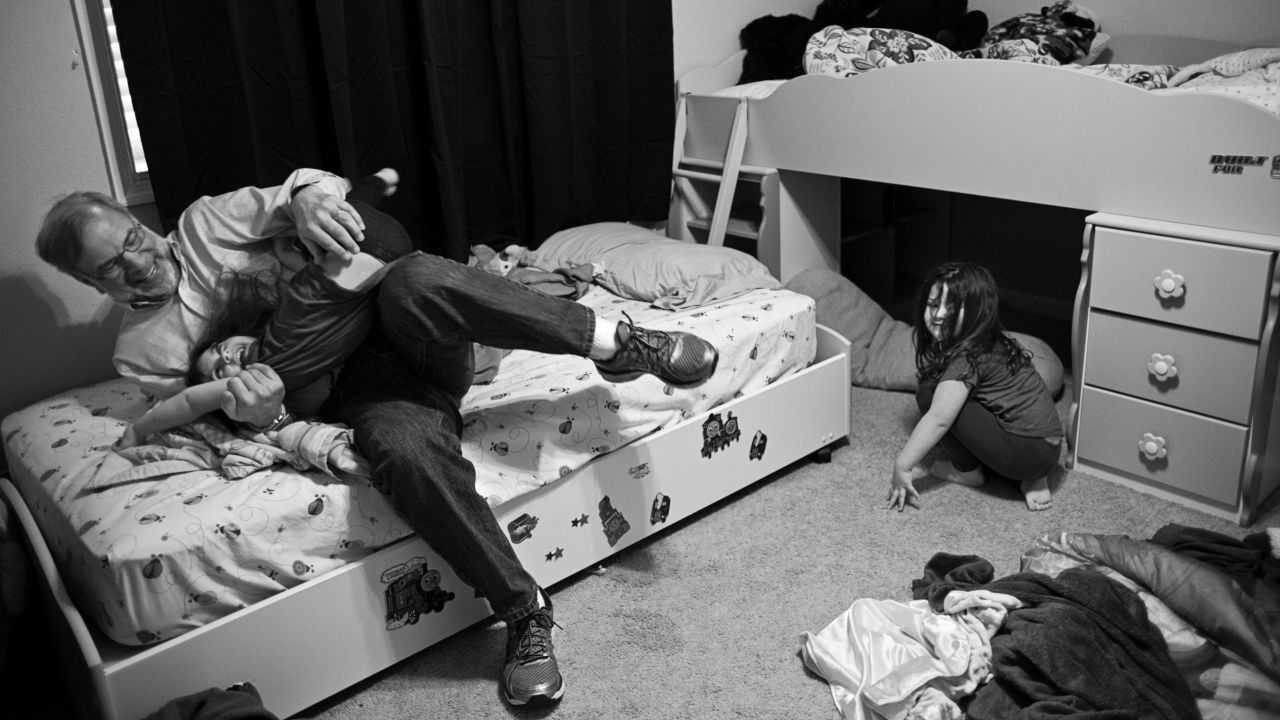 Sandy Halperin tickles his granddaughter, Madeline, while his granddaughter, Rebecca, looks on.