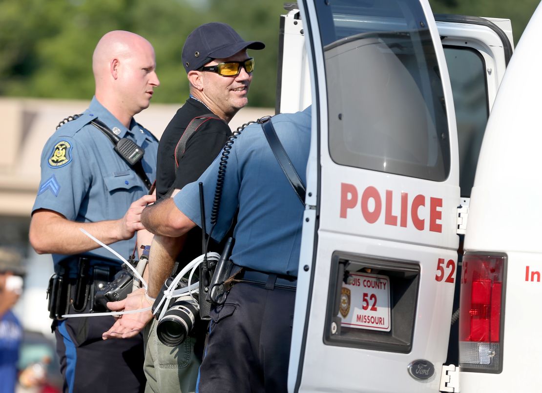 Getty Images staff photographer Scott Olson is placed into a paddy wagon after being arrested.
