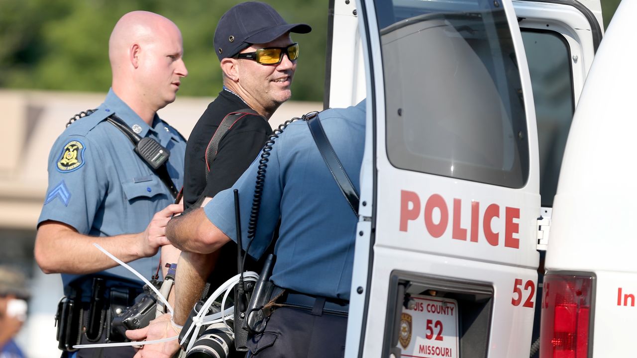 Getty Images staff photographer Scott Olson is placed into a paddy wagon after being arrested.