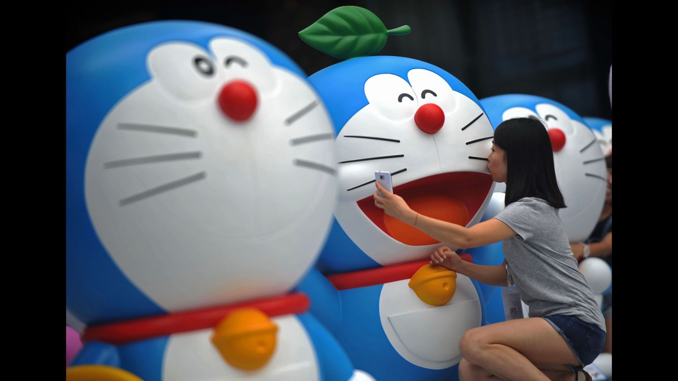 A visitor takes a selfie with a Doraemon figure during a Doraemon exhibition in Chengdu, China, on Saturday, August 16. Doraemon, a robotic cat from the 22nd century, has been a popular anime character since 1969.