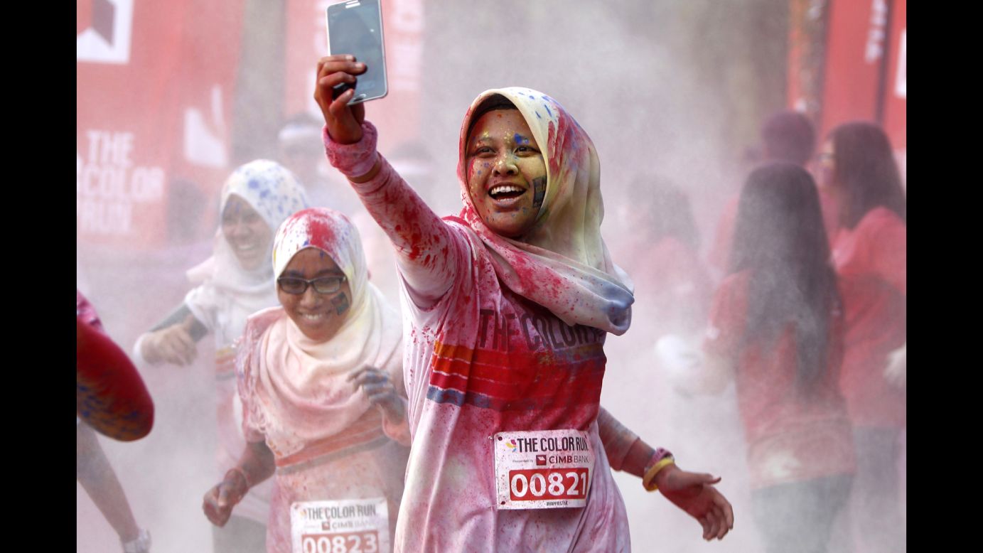 A woman takes a selfie as she runs through a "color station" during the Color Run in Kuala Lumpur, Malaysia, on Sunday, August 17. The race, billed as <a href="http://thecolorrun.com" target="_blank" target="_blank">"the happiest 5K on the planet,"</a> involves lots of colored powder and takes place in different cities worldwide throughout the year.