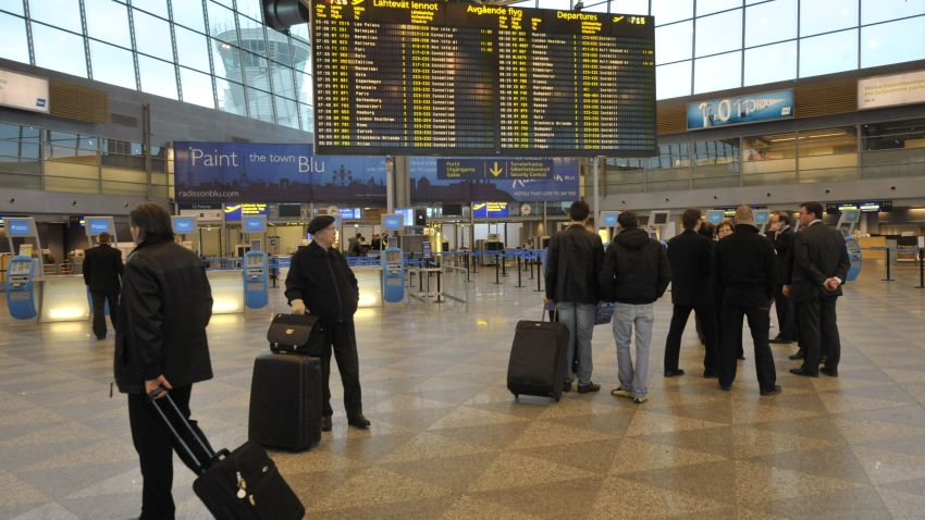 Passengers gather beside an information board at Helsinki Airport on April 16, 2010, following the cancellation of flights. Flight restrictions due to ash from an Iceland volcano have been extended across Finland and are expected to last 'several days', airport operator Finavia said