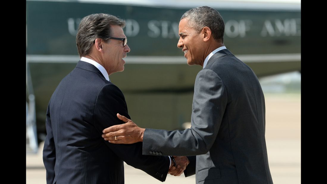 Perry greets President Barack Obama as he arrives in Dallas on July 9, 2014, for a meeting with local elected officials and faith leaders about the humanitarian situation at the Southwest border.