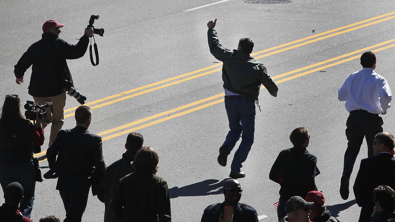Perry runs the Veterans Day parade route in Columbia, South Carolina, while local media and his security detail jog along to keep up on November 11, 2011.