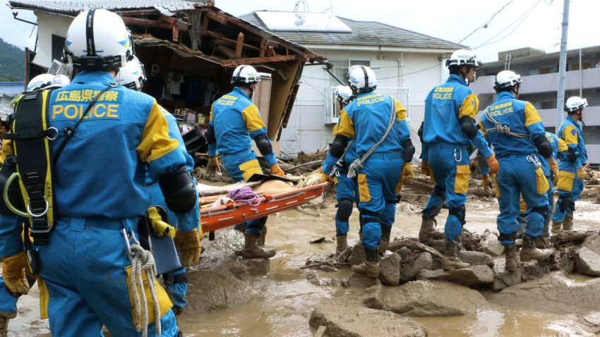 A troop of police rescue personnel head out for rescue operation after a massive landslides swept through residential area in Hiroshima, western Japan, Wednesday, Aug. 20, 2014.