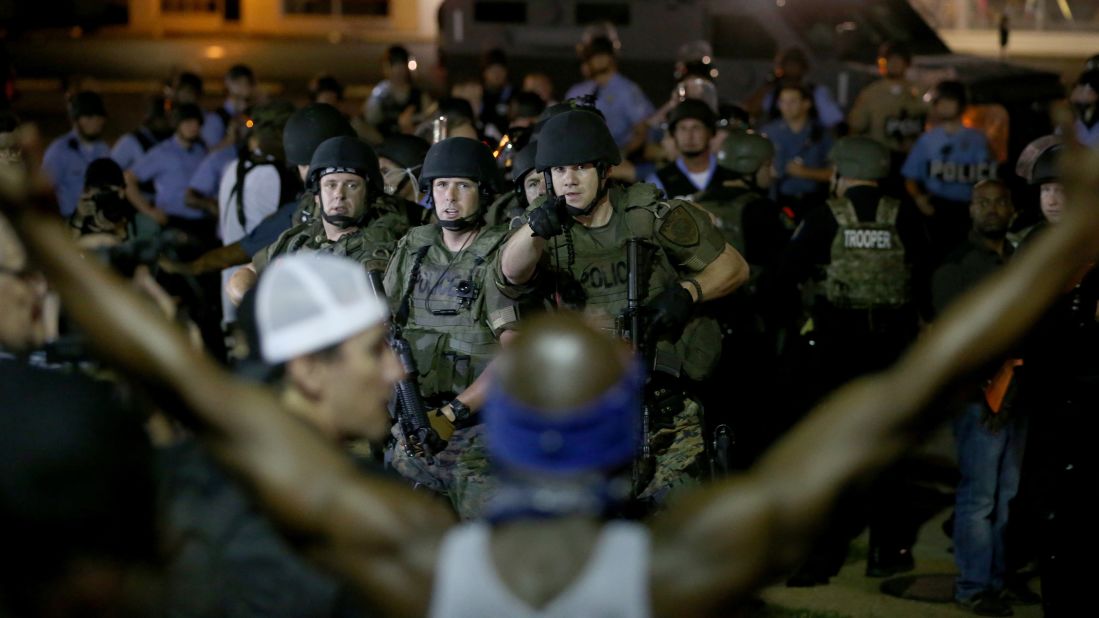 Police point out a demonstrator who has his arms raised before moving in to arrest him Tuesday, August 19, 2014.