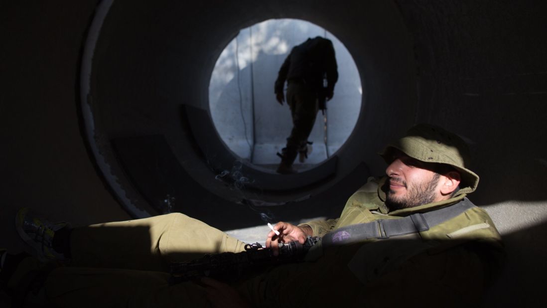 An Israeli soldier smokes a cigarette in a large concrete pipe used as shelter at an army deployment point near the Israeli-Gaza border on Wednesday, August 20. 