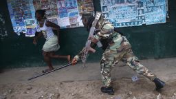 MONROVIA, LIBERIA - AUGUST 20:  A Liberian Army soldier, part of the Ebola Task Force, beats a local resident while enforcing a quarantine on the West Point slum on August 20, 2014 in Monrovia, Liberia. The government ordered the quarantine of West Point, a congested seaside slum of 75,000, on Wednesday, in an effort to stop the spread of the virus in the capital city. Liberian soldiers were also sent in to the seaside favela to extract West Point Commissioner Miata Flowers and her family members after residents blamed the government for setting up a holding center for suspected Ebola patients to be set up in their community. A mob overran and closed the facility on August 16. The military also began enforcing a quarrantine on West Point, a congested slum of 75,000, fearing a spread of the epidemic. The Ebola virus has killed more than 1,200 people in four African nations, more in Liberia than any other country.  (Photo by John Moore/Getty Images)