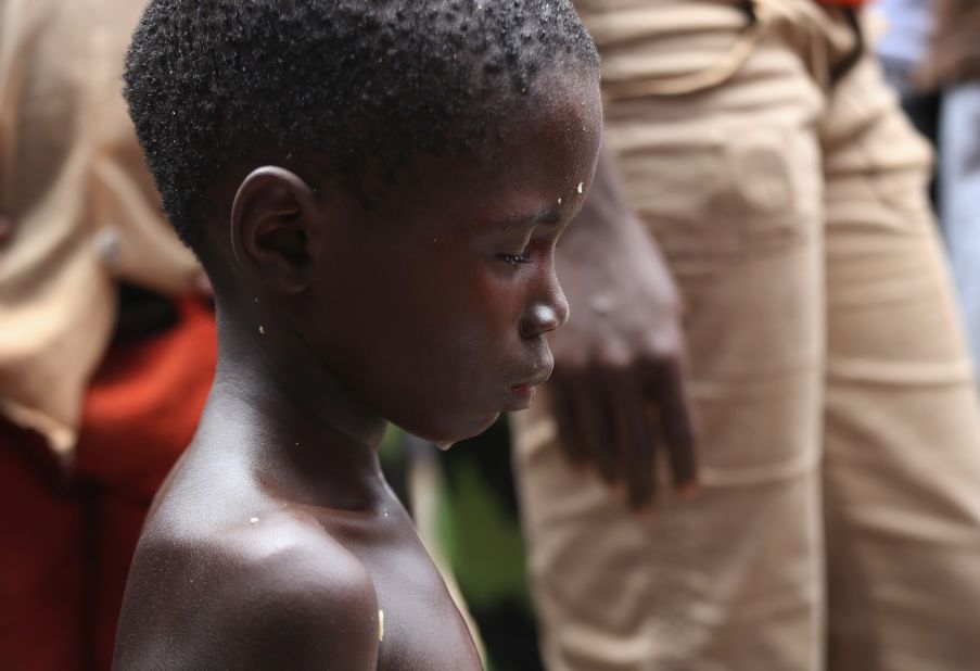 Local residents gather around a very sick Saah Exco, 10, in a back alley of the West Point slum on August 19, 2014. The boy was one of the patients that was pulled out of a holding center for suspected Ebola patients after the facility was overrun and closed by a mob on August 16. A local clinic then refused to treat Saah, according to residents, because of the danger of infection. Although he was never tested for Ebola, Saah's mother and brother died in the holding center.