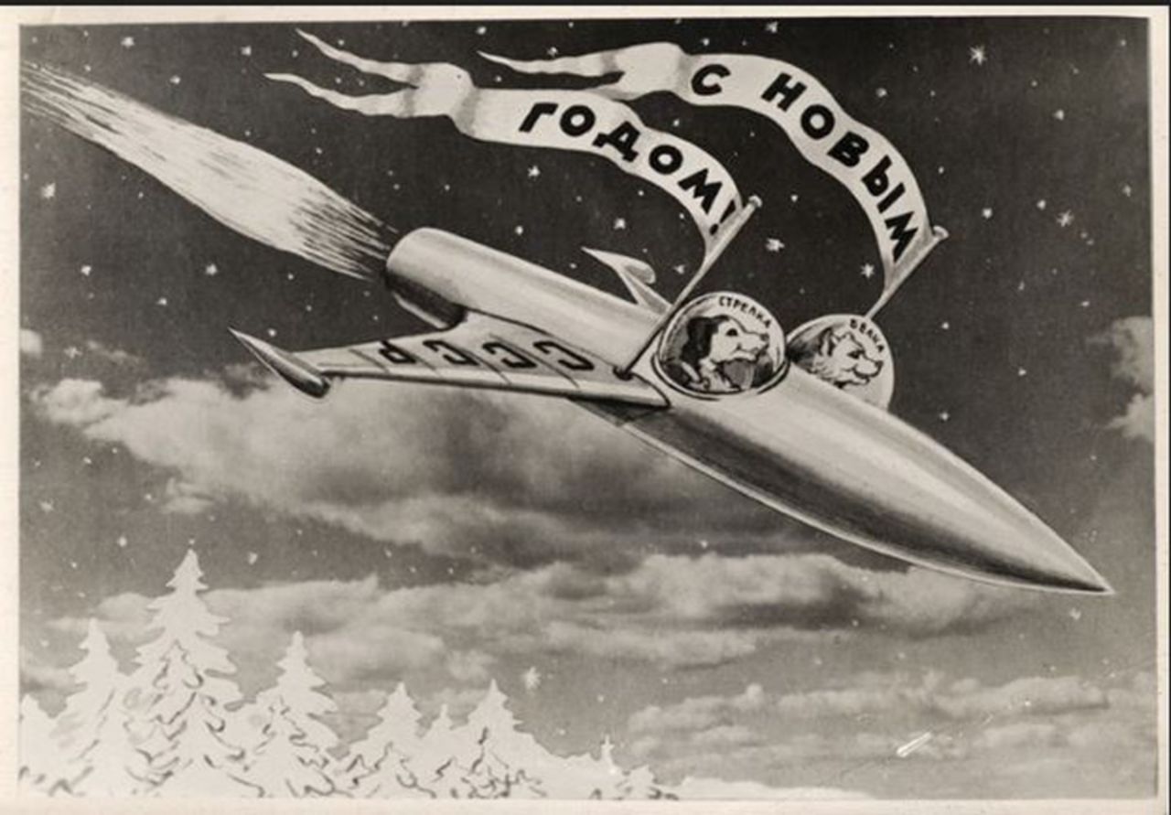This postcard (1960), by the photomontage artist Sveshnikov, shows the dogs Belka and Strelka in their rocket. The flags read "Happy New Year".<br />