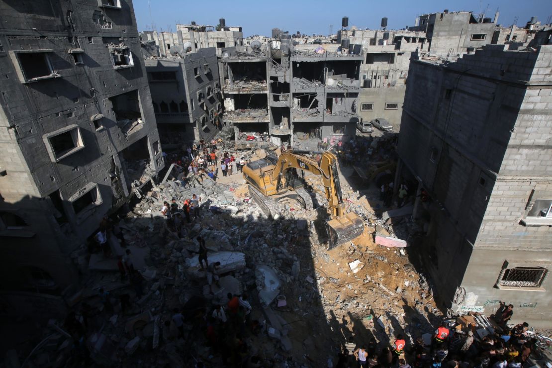 Palestinian emergency personnel dig through the rubble of a building destroyed in an Israeli military strike in Rafah in the south of Gaza on August 21, 2014.