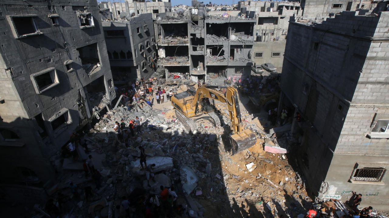 Palestinian emergency personnel dig through the rubble of a building destroyed in an Israeli military strike in Rafah in the south of Gaza on August 21, 2014.