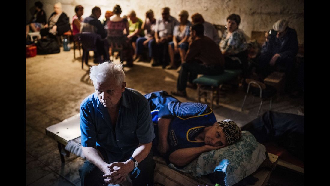 Residents sit in a makeshift bomb shelter during a shelling in Makiivka on Wednesday, August 20.