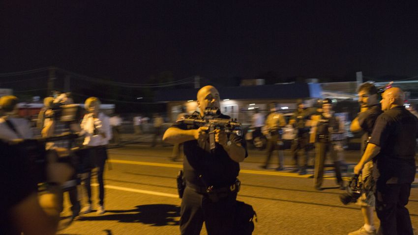 FERGUSON, MO - AUGUST 19:  St. Ann, Missouri police officer Lt. Ray Albers points an assault rifle at a protester of the death of teenager Michael Brown August 19, 2014 in Ferguson, Missouri. Albers, who was forced to lower his weapon and escorted from the area by a police sergeant according to a statement released by the St. Louis County Police Department, was relieved of duty and suspended indefinitely August 20. Albers has been been with the St. Ann Police Department since 1994, according to a published report.  (Photo by Aaron P. Bernstein/Getty Images)