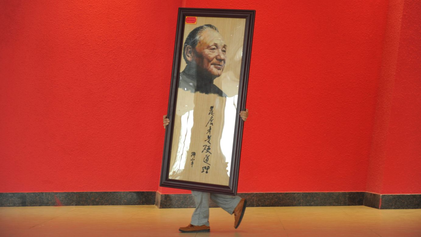 A worker moves a portrait of former Chinese leader Deng Xiaoping at an exhibition in Deng's hometown of Guangyuan, China, on Monday, August 18. The exhibition celebrated the 110th anniversary of the late leader's birth. 